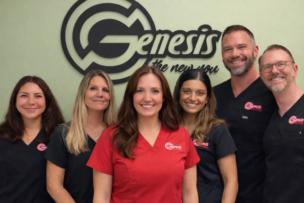 Serenity Harris and the Genesis Red Light team in front of the Genesis logo